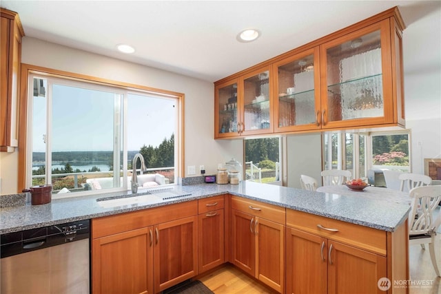 8082 Daniel Pl NW, Silverdale, WA 98383 - kitchen with stainless steel dishwasher, a sink, light stone countertops, a peninsula, and healthy amount of natural light