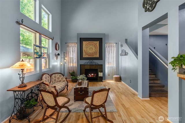 782 Fenway Ln SW, Tumwater, WA 98512 - living room featuring a towering ceiling, wood finished floors, stairs, a tile fireplace, and baseboards