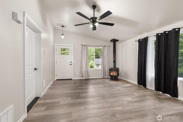 18822 Rampart Dr SE, Yelm, WA 98597 - entryway with lofted ceiling, a ceiling fan, a wood stove, wood finished floors, and baseboards