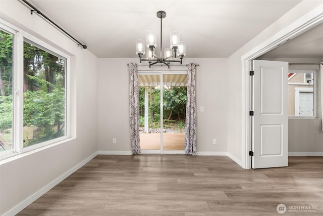 18822 Rampart Dr SE, Yelm, WA 98597 - unfurnished dining area with plenty of natural light, a chandelier, and baseboards