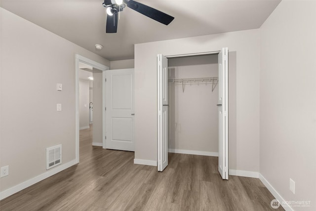 18822 Rampart Dr SE, Yelm, WA 98597 - unfurnished bedroom featuring wood finished floors, baseboards, a ceiling fan, and a closet