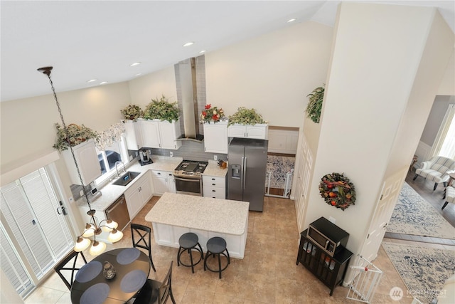 23813 109th Street Ct E, Buckley, WA 98321 - kitchen featuring appliances with stainless steel finishes, a sink, wall chimney range hood, high vaulted ceiling, and white cabinets