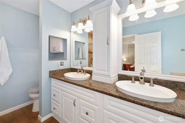 23813 109th Street Ct E, Buckley, WA 98321 - bathroom featuring double vanity, toilet, wood finished floors, and baseboards