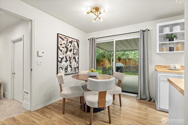 19019 Grannis Rd, Bothell, WA 98012 - dining room with light wood-type flooring, a chandelier, and baseboards