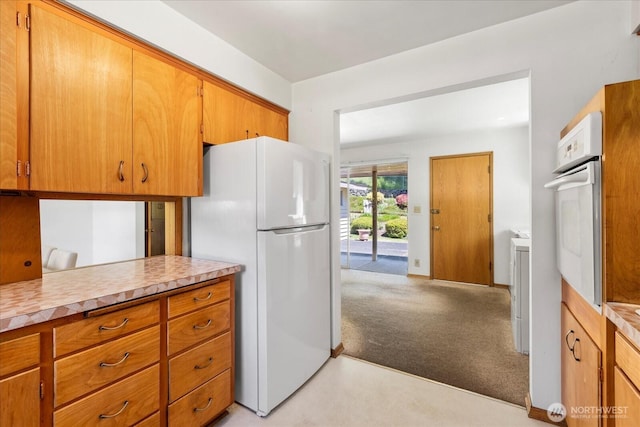 1420 Olympic Ave, Edmonds, WA 98020 - kitchen with white appliances, light carpet, light countertops, brown cabinetry, and baseboards