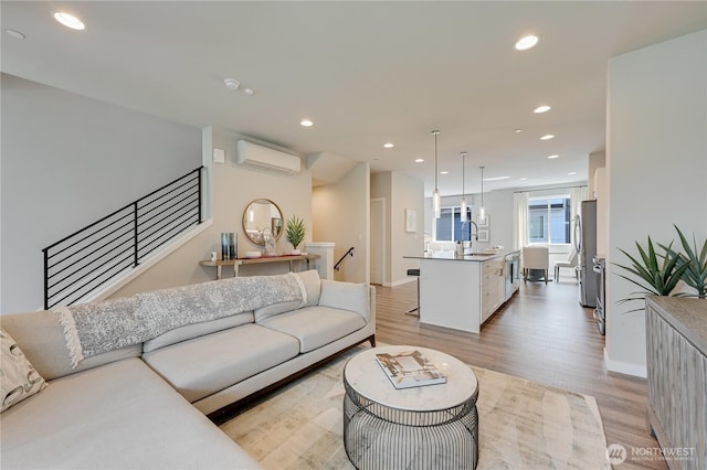 2349 N 147th St Unit B, Shoreline, WA 98133 - living room featuring a wall mounted AC, recessed lighting, light wood-style flooring, stairway, and baseboards