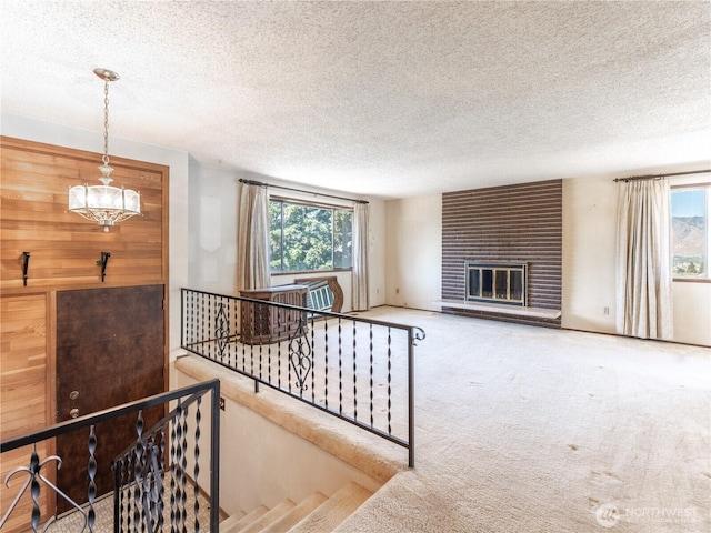 604 N Larch Ave, East Wenatchee, WA 98802 - living area with a textured ceiling, carpet flooring, a fireplace, and a chandelier