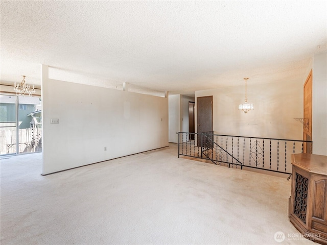 604 N Larch Ave, East Wenatchee, WA 98802 - empty room with a chandelier, carpet floors, and a textured ceiling