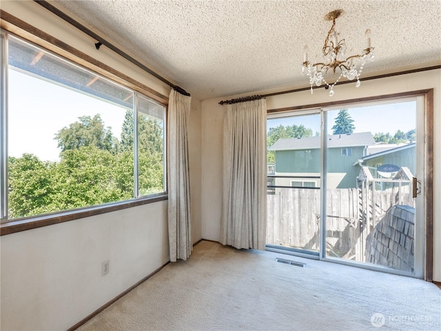 604 N Larch Ave, East Wenatchee, WA 98802 - carpeted empty room with a textured ceiling and a chandelier