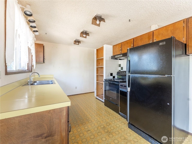 604 N Larch Ave, East Wenatchee, WA 98802 - kitchen featuring black appliances, a sink, under cabinet range hood, brown cabinetry, and light countertops