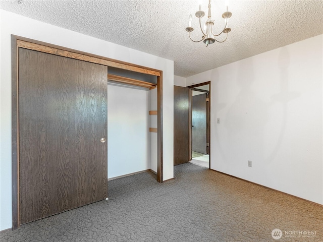 604 N Larch Ave, East Wenatchee, WA 98802 - unfurnished bedroom with carpet floors, a chandelier, a textured ceiling, a closet, and baseboards