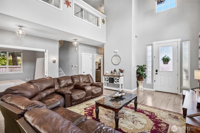8712 177th St E, Puyallup, WA 98375 - living room with wood finished floors, stairway, a towering ceiling, and baseboards