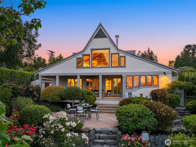 1237 Hawley Way NE, Bainbridge Island, WA 98110 - back of house at dusk with covered porch and a patio area