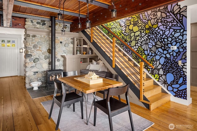 1237 Hawley Way NE, Bainbridge Island, WA 98110 - dining area featuring wood-type flooring, a wood ceiling with exposed beams, a wood stove, and stairs