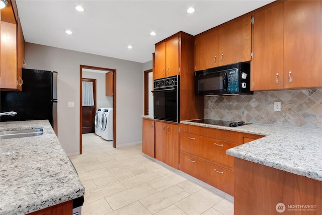 10202 Pipeline Rd E, Puyallup, WA 98373 - kitchen with black appliances, independent washer and dryer, a sink, brown cabinetry, and decorative backsplash