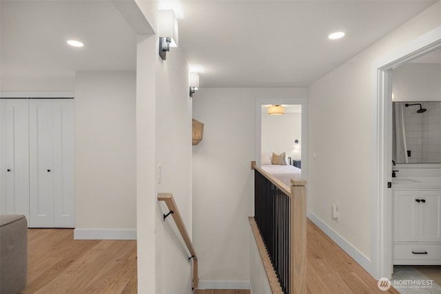 7201 Seward Park Ave S, Seattle, WA 98118 - hallway with an upstairs landing, light wood-style flooring, baseboards, recessed lighting, and a sink