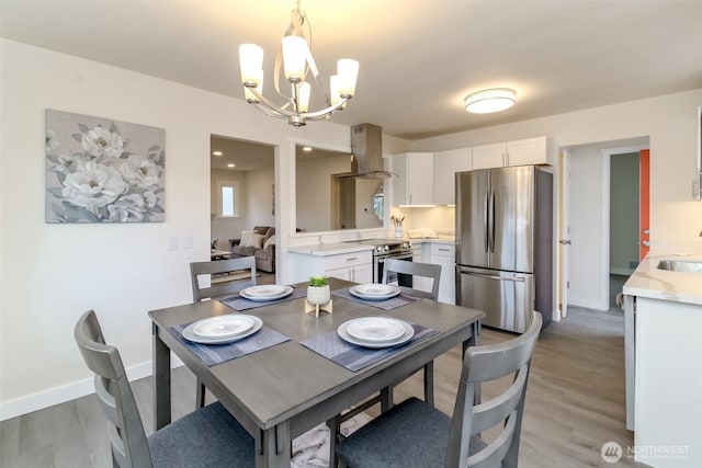 2914 S 17th St, Tacoma, WA 98405 - dining area featuring a chandelier, light wood-type flooring, and baseboards