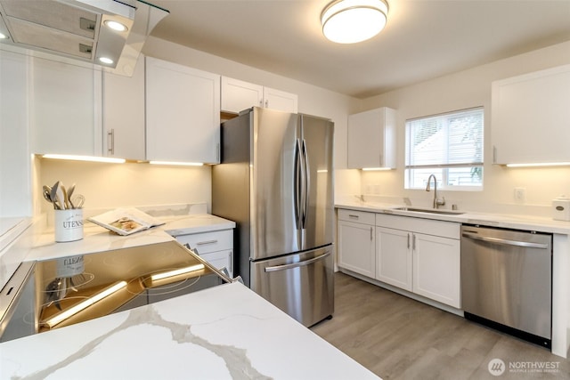 2914 S 17th St, Tacoma, WA 98405 - kitchen featuring stainless steel appliances, a sink, white cabinets, light wood-type flooring, and light stone counters