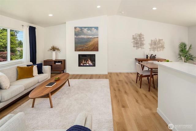 303 NE 133rd St, Seattle, WA 98125 - living room featuring light wood-style flooring, a glass covered fireplace, recessed lighting, baseboards, and lofted ceiling