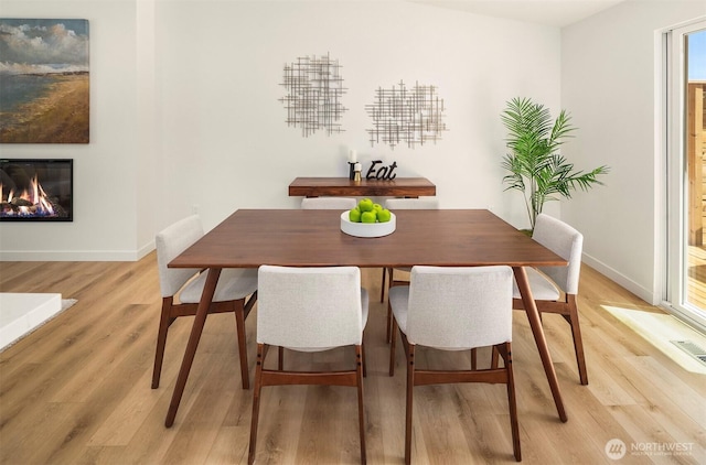 303 NE 133rd St, Seattle, WA 98125 - dining area featuring light wood-style floors, baseboards, and a glass covered fireplace