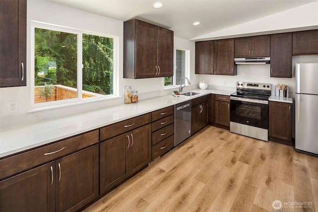 303 NE 133rd St, Seattle, WA 98125 - kitchen featuring stainless steel appliances, under cabinet range hood, a sink, vaulted ceiling, and light wood-style flooring