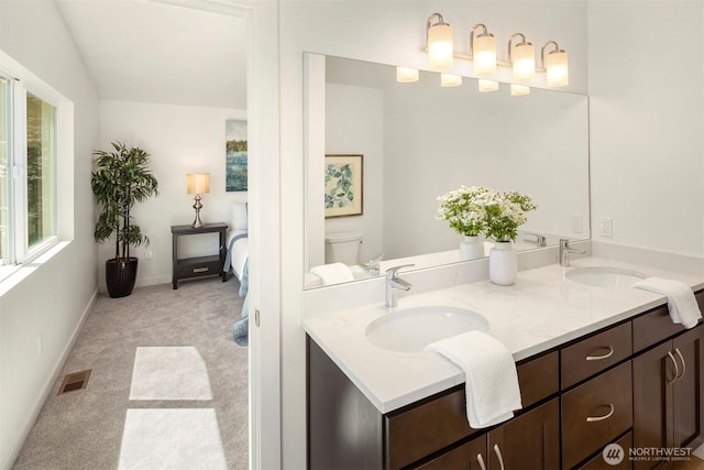 303 NE 133rd St, Seattle, WA 98125 - bathroom featuring double vanity, toilet, and baseboards