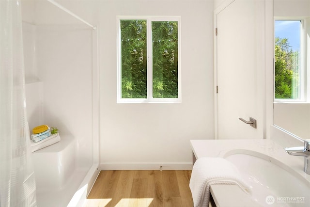 303 NE 133rd St, Seattle, WA 98125 - full bathroom with wood finished floors, a shower, vanity, and baseboards