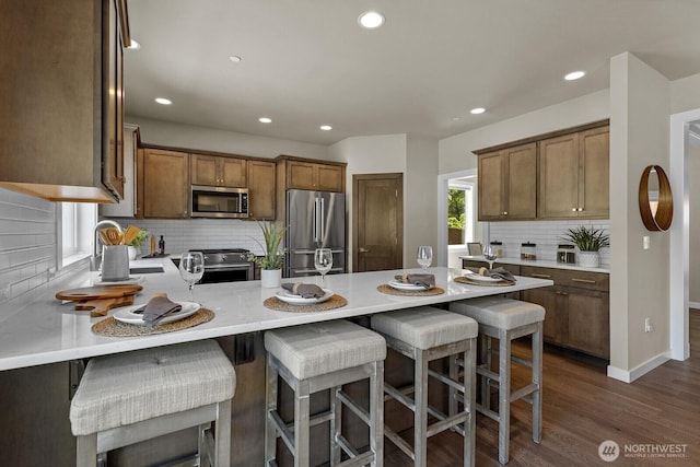 1794 Granite Way SE, North Bend, WA 98045 - kitchen with stainless steel appliances, a peninsula, backsplash, recessed lighting, and dark wood-style floors