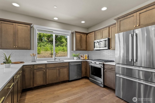 1794 Granite Way SE, North Bend, WA 98045 - kitchen with appliances with stainless steel finishes, a sink, light wood-type flooring, backsplash, and recessed lighting