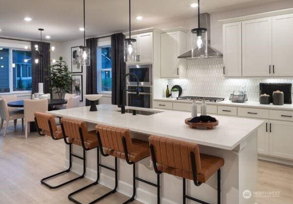 2627 Acer Loop SE, Lacey, WA 98513 - kitchen with wall chimney range hood, light wood-style flooring, backsplash, white cabinetry, and recessed lighting