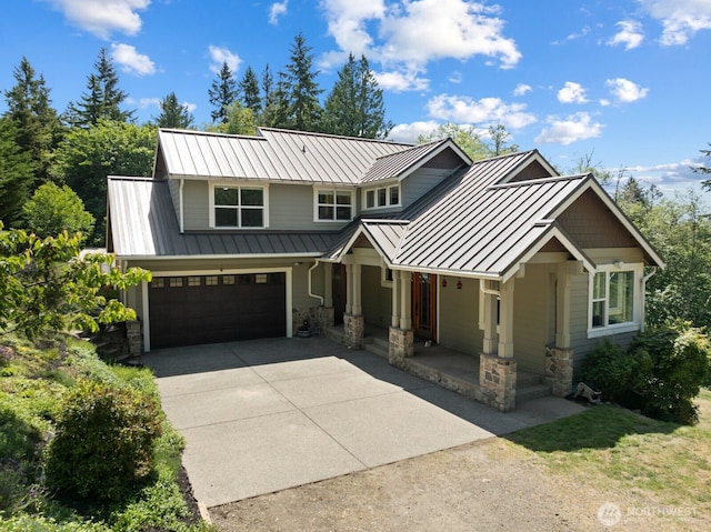 5675 E Hillcrest Dr, Port Orchard, WA 98366 - view of front of house featuring a standing seam roof, concrete driveway, stone siding, a porch, and metal roof