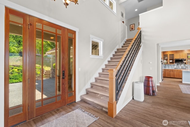 5675 E Hillcrest Dr, Port Orchard, WA 98366 - entrance foyer featuring french doors, stairs, a high ceiling, wood finished floors, and baseboards