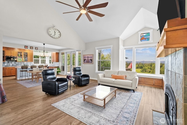 5675 E Hillcrest Dr, Port Orchard, WA 98366 - living room with high vaulted ceiling, ceiling fan, light wood-type flooring, and a chandelier