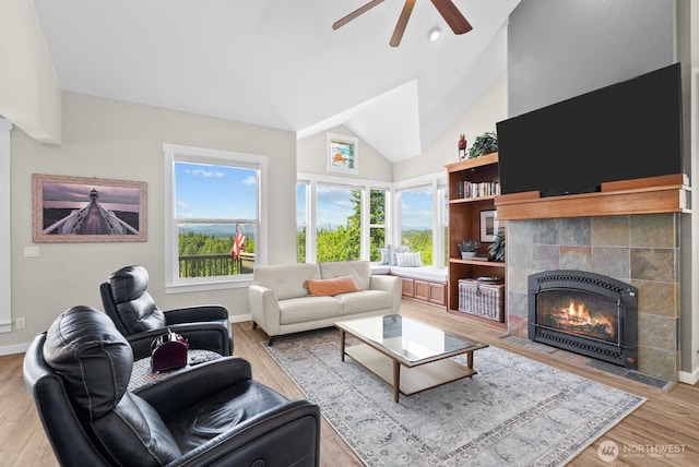 5675 E Hillcrest Dr, Port Orchard, WA 98366 - living area with a tile fireplace, lofted ceiling, a ceiling fan, plenty of natural light, and wood finished floors