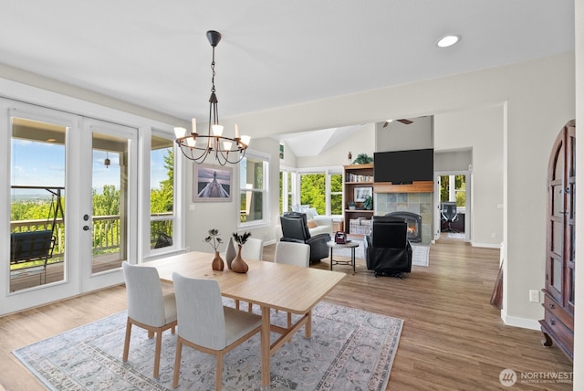 5675 E Hillcrest Dr, Port Orchard, WA 98366 - dining area featuring a chandelier, a fireplace, french doors, wood finished floors, and vaulted ceiling