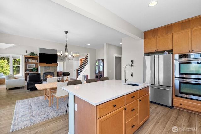 5675 E Hillcrest Dr, Port Orchard, WA 98366 - kitchen with stainless steel appliances, a sink, a tile fireplace, light wood finished floors, and recessed lighting