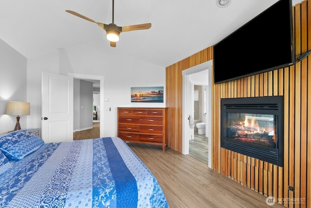 5675 E Hillcrest Dr, Port Orchard, WA 98366 - bedroom featuring wood finished floors, a glass covered fireplace, ensuite bathroom, ceiling fan, and baseboards