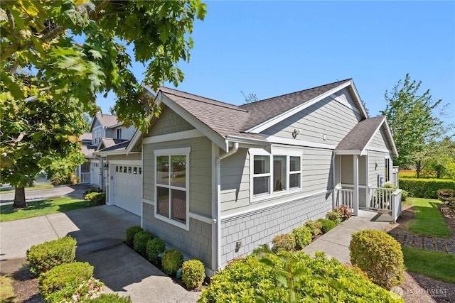 509 Clover Ln, Bellingham, WA 98226 - view of side of property featuring roof with shingles, concrete driveway, and a garage
