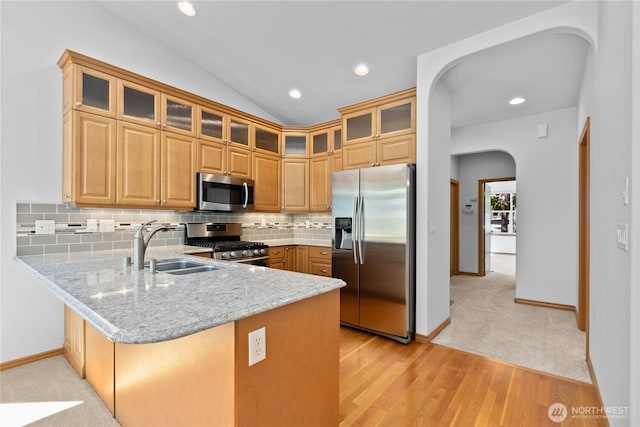 509 Clover Ln, Bellingham, WA 98226 - kitchen with appliances with stainless steel finishes, a sink, a peninsula, arched walkways, and light stone counters