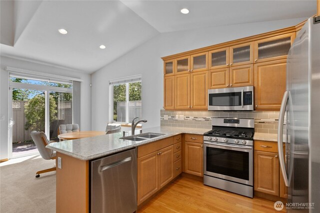 509 Clover Ln, Bellingham, WA 98226 - kitchen with stainless steel appliances, a sink, vaulted ceiling, a peninsula, and light stone counters