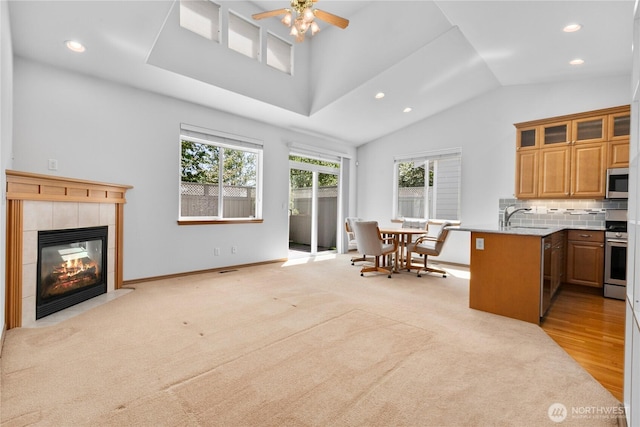 509 Clover Ln, Bellingham, WA 98226 - kitchen featuring appliances with stainless steel finishes, vaulted ceiling, recessed lighting, glass insert cabinets, and a tiled fireplace