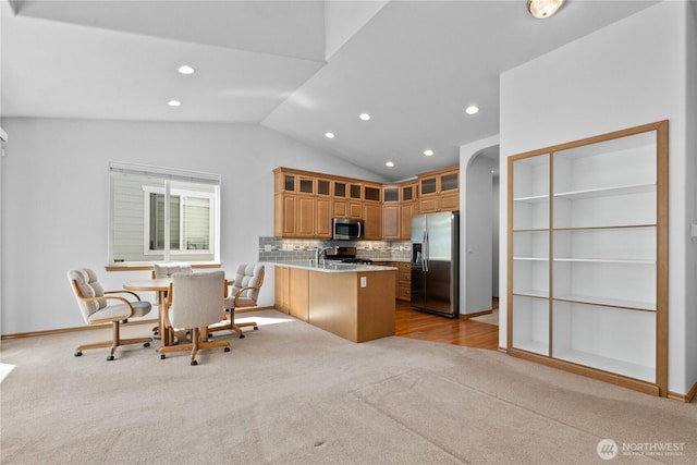 509 Clover Ln, Bellingham, WA 98226 - kitchen with appliances with stainless steel finishes, a peninsula, lofted ceiling, glass insert cabinets, and recessed lighting