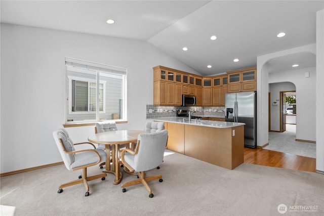 509 Clover Ln, Bellingham, WA 98226 - kitchen featuring stainless steel appliances, light colored carpet, a peninsula, vaulted ceiling, and arched walkways