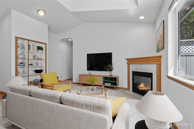 509 Clover Ln, Bellingham, WA 98226 - living room with a tiled fireplace, arched walkways, lofted ceiling, and baseboards