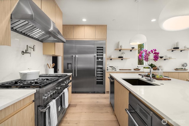 3973 162nd Pl SE, Bellevue, WA 98006 - kitchen with wall chimney range hood, high quality appliances, a sink, light brown cabinets, and recessed lighting