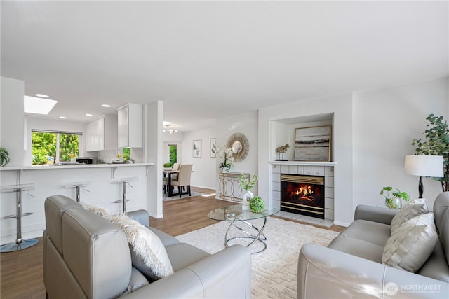 7718 NE 183rd St, Kenmore, WA 98028 - living area with wood finished floors, recessed lighting, a skylight, a tile fireplace, and baseboards