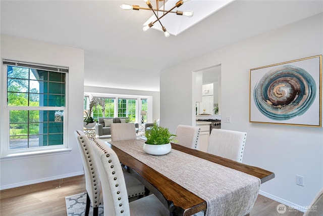 7718 NE 183rd St, Kenmore, WA 98028 - dining area with a chandelier, healthy amount of natural light, baseboards, and light wood-style floors