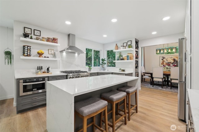 27716 NE 30th St, Redmond, WA 98053 - kitchen featuring wall chimney range hood, open shelves, stainless steel appliances, gray cabinetry, and a kitchen breakfast bar