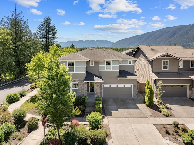 303 Vaughan Blvd NE, North Bend, WA 98045 - view of front of property featuring stone siding, a mountain view, a garage, concrete driveway, and a shingled roof