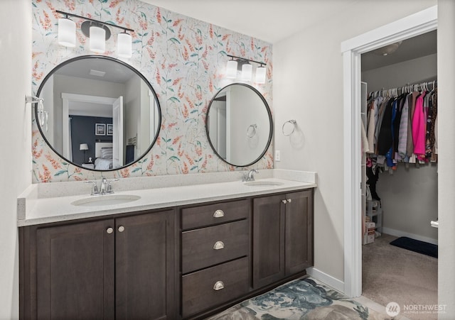 303 Vaughan Blvd NE, North Bend, WA 98045 - bathroom with wallpapered walls, double vanity, a spacious closet, and baseboards